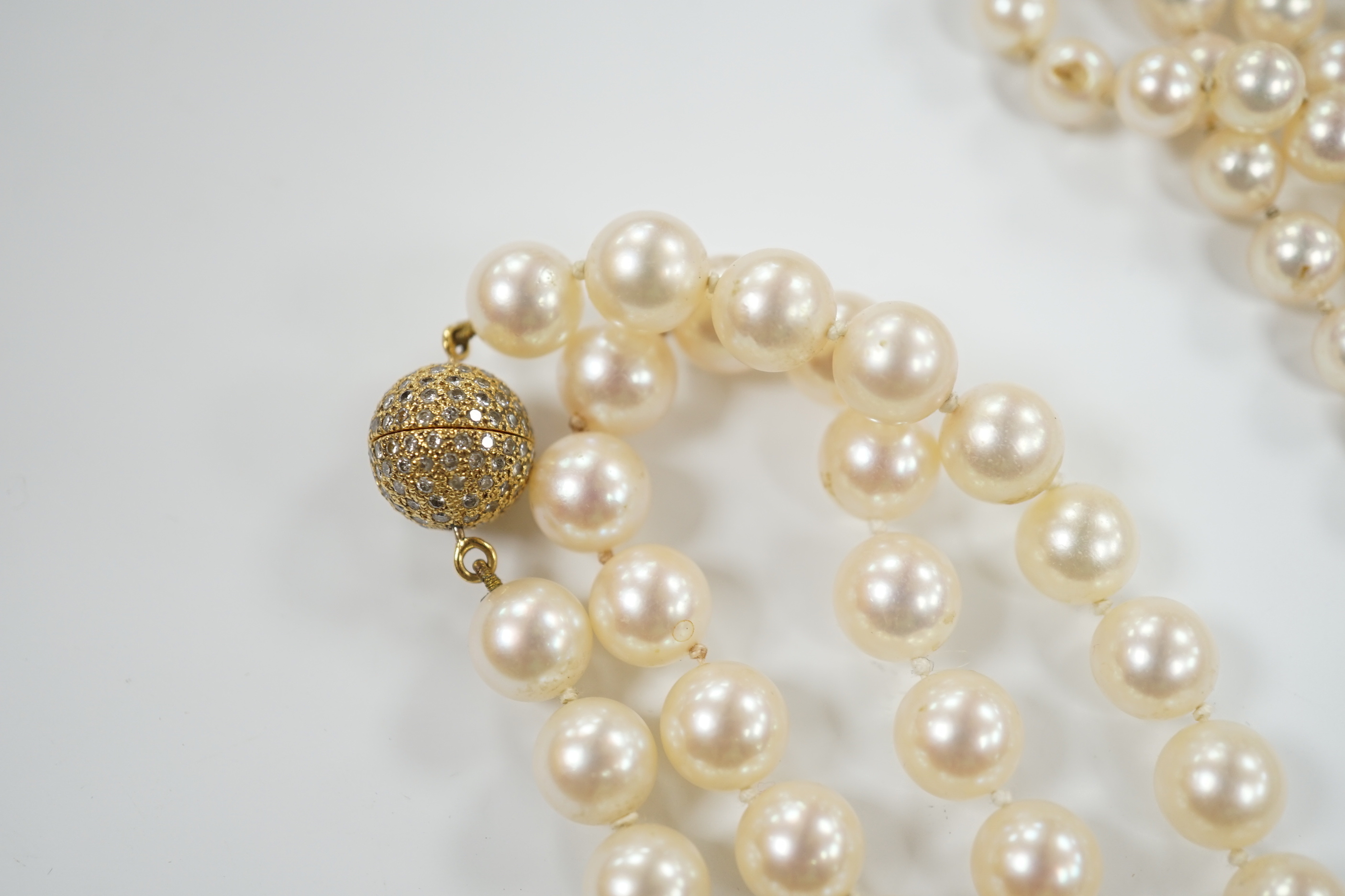 A single strand cultured pearl necklace, with diamond chip set 18ct gold clasp, 74cm and similar bracelet with diamond mounted clasps together with another cultured pearl necklace.